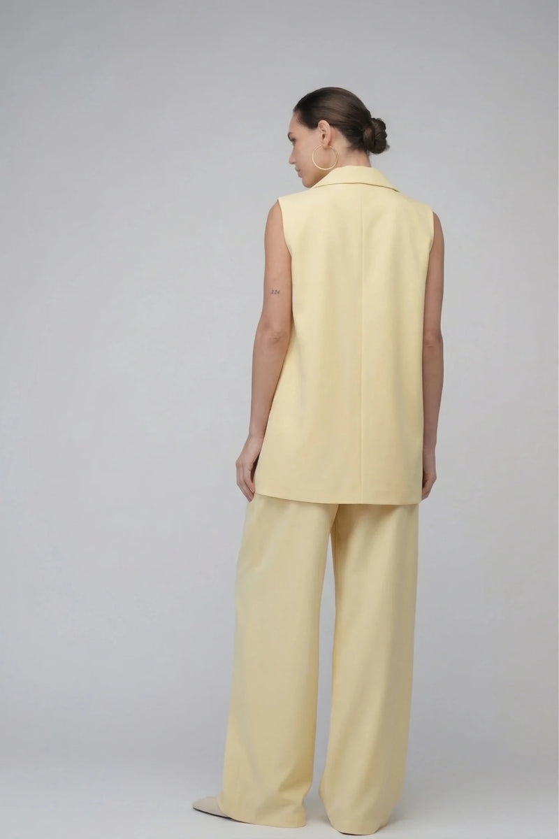 Дамски Комплект "Cyrene" в цвят банан за смела, модерна жена. Кройката без ръкави и широките панталони